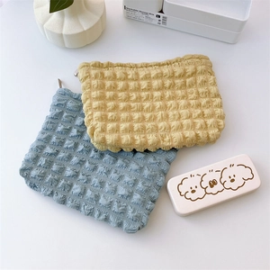 Detail of puffy bubble texture quilted cosmetic bags in yellow and light blue colors
