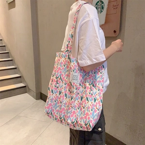 Vue détaillée latérale du sac cabas en toile à fleurs avec motifs tulipes et tissu tissé