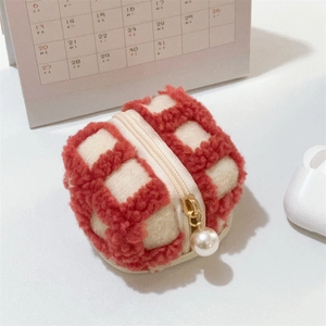 Close-up of red waffle fleece pouch with gold zipper and decorative pearl pendant
