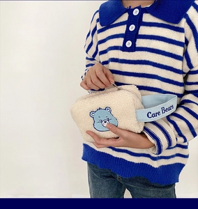 Détail de la pochette peluche ours avec broderie et dragonne bleue de marque assortie