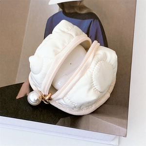 Detail of white puffer quilted earphone case with a stylish large pearl zipper pull