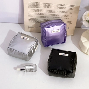 Three metallic faux leather portable makeup pouches in silver, purple, and black colors
