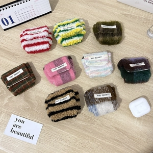 Bovenaanzicht van kleurrijke gebreide oortelefoonhoesjes op een houten tafelblad