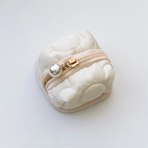 Close-up of quilted floral earphone pouch with a large decorative pearl zipper puller