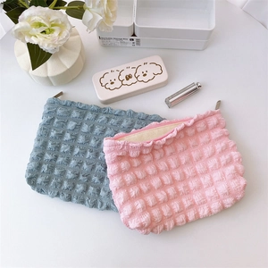 Detailed close-up of pink and blue bubble texture fabric cosmetic bags with metal zippers