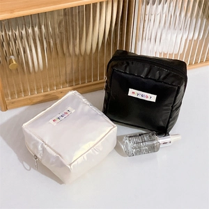 Detail of square waterproof nylon cosmetic pouch with moyrabbit logo and top zipper
