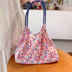 Dettaglio della grande borsa tote in tela con stampa a tulipani e robusti manici in corda blu