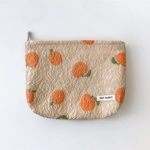 Detail of embossed floral jacquard fabric with orange pattern and metal zipper closure