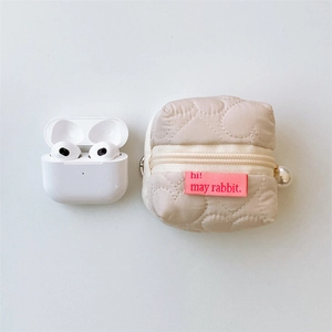 Vue détaillée d'une pochette beige matelassée en cœur avec breloque perle et fermeture éclair