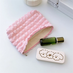 Detailed view of pink bubble puff makeup bag with silver zipper and inner lining