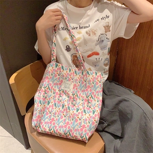 Détail du sac cabas en toile à fleurs avec motifs tulipes et étiquette LOVE