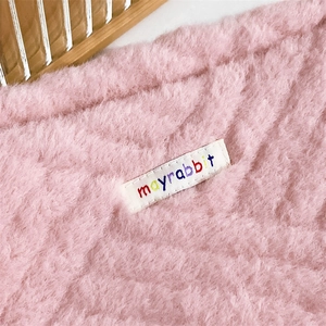 Close-up of pink plush canvas bag with soft texture and mayrabbit embroidered label