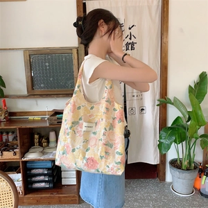 Détail du sac cabas en toile à fleurs avec tulipes roses et écusson de marque
