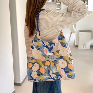 Dettaglio della grande borsa tote floreale con etichetta May Rabbit e spalline blu