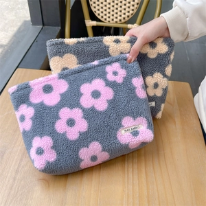 Close-up of soft floral sherpa fleece cosmetic bags with detailed plush flower pattern
