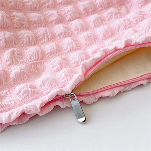 Detailed macro view of pink bubble texture fabric and durable metal zipper of the bag