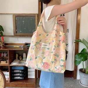 Détail du sac cabas en toile à fleurs avec motifs roses et étiquette HAY RABBIT