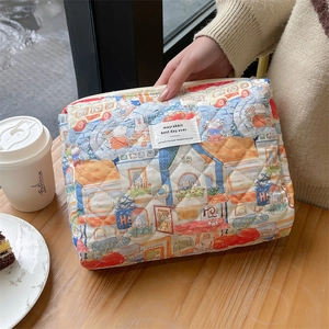 Quilted cotton floral makeup bag with illustration patterns on a cozy wooden table