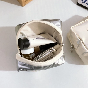 Macro shot of silver metallic makeup bag showing large capacity for skincare bottles