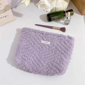 Detailed view of plush purple makeup bag with woven texture and premium zipper closure