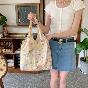 Gros plan d'un sac cabas en toile à fleurs avec imprimés tulipes et étiquette tissée