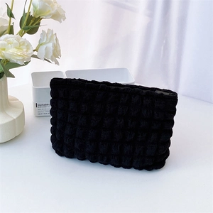 Close-up of black quilted bubble texture fabric and zipper on a large cosmetic bag