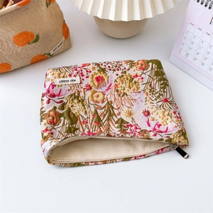 Detailed macro view of floral embossed jacquard makeup bag with May Rabbit label