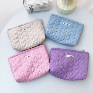 Quilted heart cosmetic bags in beige, blue, pink and purple with zipper and logo label