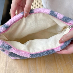 Detail view of large capacity plush cosmetic bag with pink checkered pattern and inner lining