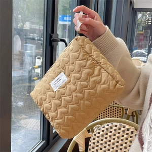 Detail of yellow quilted heart pouch featuring premium stitching and durable nylon handle