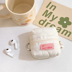 Close-up of quilted white mini pouch with pearl charm and metal hook for earphones