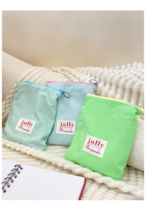 Vue détaillée de trois pochettes en tissu aux tons macarons avec fermeture à glissière ronde