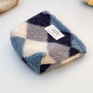 Macro detail of plush checkered mini pouch with soft blue and grey fabric texture