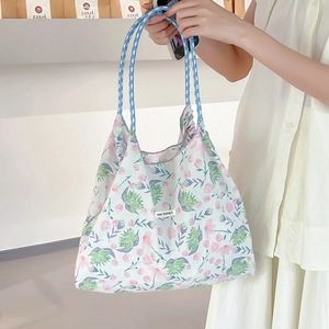 Dettaglio della borsa tote in tela floreale con etichetta May Rabbit e manici a pois blu