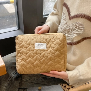 Close-up of quilted heart pattern and textile label on the khaki makeup organizer bag