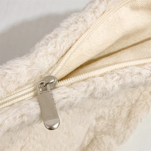 Detailed close-up of high-quality metal zipper on a soft plush beige canvas storage bag