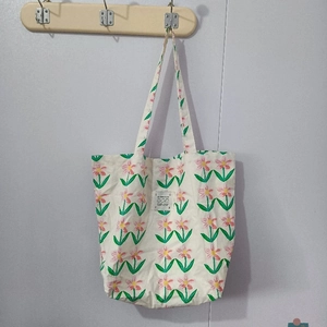 Détail du sac cabas en toile à fleurs roses avec étiquette graphique texte LOVE