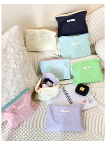 Flat lay of colorful nylon makeup bags showing large storage capacity and zipper detail