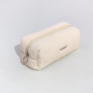 Detailed close-up of cream fuzzy fleece pencil case with rainbow brand tag and metal zipper