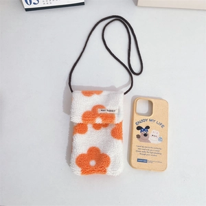 Détail de la pochette téléphone en peluche avec motif floral orange et étiquette May