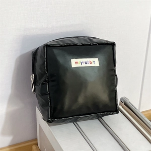Detail of matte waterproof leather portable square makeup bag with logo patch and metal zipper
