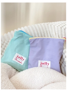 Détail de petites trousses à maquillage en nylon vert menthe et violet avec fermetures