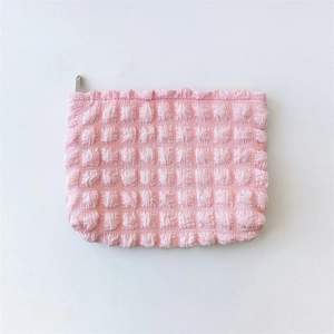 Detail of pink bubble texture fabric on a large capacity cosmetic bag with zip closure