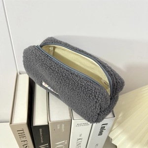 Close-up of plush grey fleece pouch with zipper, beige lining and soft wool texture