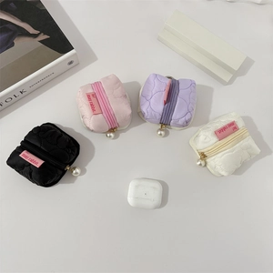 Detailed view of wave-quilted mini storage pouches in four colors for earphones and coins