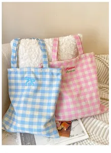 Detail shot of plaid canvas tote bags featuring blue bow and romantic embroidery