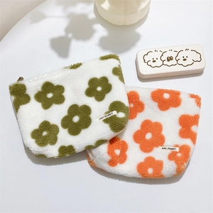 Detail of plush floral cosmetic bags showing soft lamb-like fabric and flower patterns