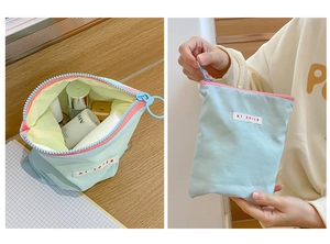 Gros plan d'une trousse à maquillage bleue avec fermeture éclair rose et étiquette