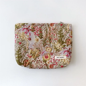 Close-up of floral jacquard texture and woven logo on the portable cosmetic pouch