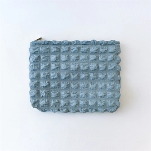 Detail of light blue bubble textured makeup bag with premium metal zipper closure